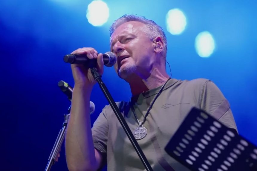 Marko Perković Thompson na sceni drži mikrofon i pjeva.