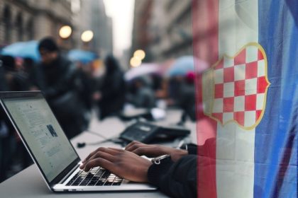 Anonimni korisnik društvenih mreža s laptopom ogrnut zastavom Herceg-Bosne.