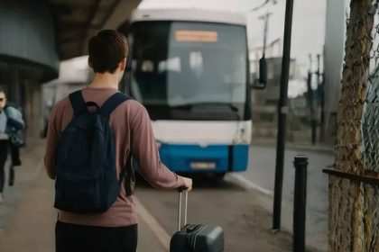 Mlada osoba stoji ispred autobusa spreman na odlazak.