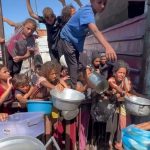 Mnoštvo djeca u Gazi čekaju da im se udjeli malo hrane.