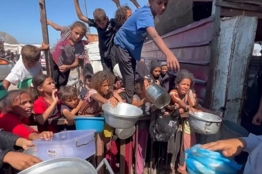 Mnoštvo djeca u Gazi čekaju da im se udjeli malo hrane.