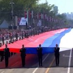 Vojnici vojske Srbije nose veliku zastavu Srbije na vojnom mimohodu u Beogradu.