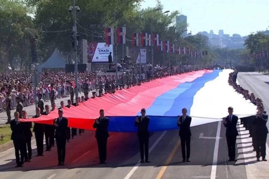Vojnici vojske Srbije nose veliku zastavu Srbije na vojnom mimohodu u Beogradu.