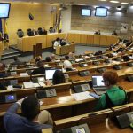 Zasjedanje Doma naroda Parlamenta Federacije BiH u polukružnoj sali, s delegatima za radnim mjestima i govornicom na sredini.