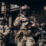 Tri vojnika u maskirnim odorama drže puške u rukama.