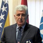 Dragan Čović daje izjavu za medije. U pozadini zastave BiH i HDZ-a BiH.