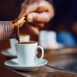 Dosipanje crne kave iz džezve u šalicu.