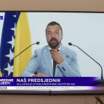 Ilustracija, imaginarni političar za govornicom. Iza njega stoji zastava BiH.