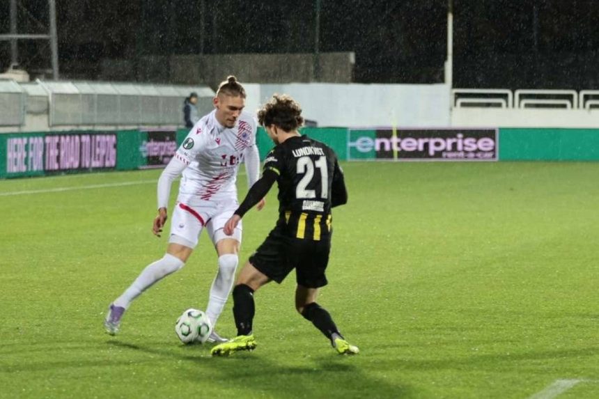 Dva nogometaša, u bijelom i crnom dresu nadmeću se za loptu.