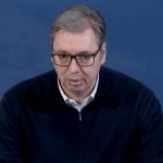 Aleksandar Vučić u crnom džemperu, iza plava pozadina.