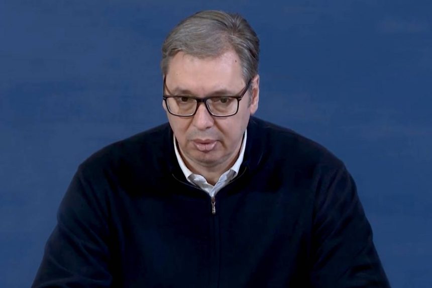 Aleksandar Vučić u crnom džemperu, iza plava pozadina.