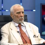 Jovan Deretić u svijetlom odjelu govori u studiju na televiziji.