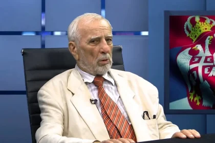 Jovan Deretić u svijetlom odjelu govori u studiju na televiziji.