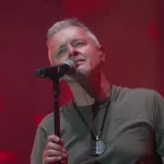 Pjevač Marko Perković Thompson na pozornici iza mikrofona.