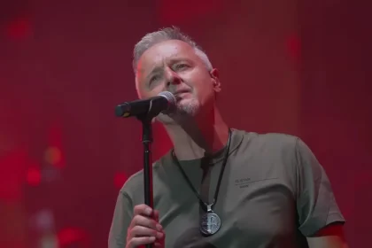 Pjevač Marko Perković Thompson na pozornici iza mikrofona.