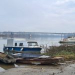 Čamci i brodice privezani uz obalu na rijeci Savi kod Orašja. U pozadini se vidi most na Savi.