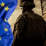 Američki vojnik okrenut leđima uz američku zastavu s desne strane. S lijeve strane u punoj širini slike europska zastava.