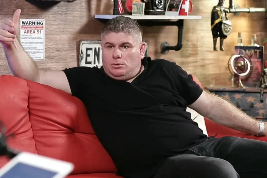 Velimir Bujanec raširenih ruku u crnoj majici na kauču u podcastu Inkubator.