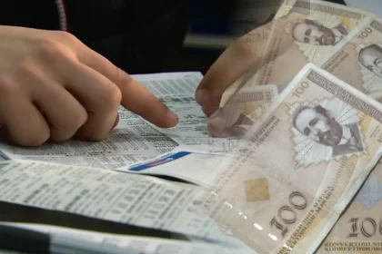 Dvije ruke iznad kladioničarskog tiketa popunjavaju tiket. Desno konvertibilne marke.