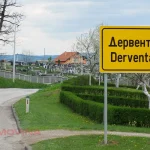 Putni prilaz gradu Derventi s putokaznom pločom u prvom planu. U pozadini groblje Rabić.