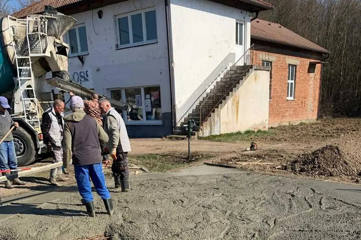 Građevinski radovi. Izlijevanje betonske ploče. Radnici pored mixera.