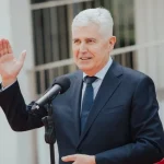Dragan Čović za govornicom uzdignute ruke.
