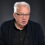 Enver Kazaz u crnom odijelu u studiju s crnom pozadinom